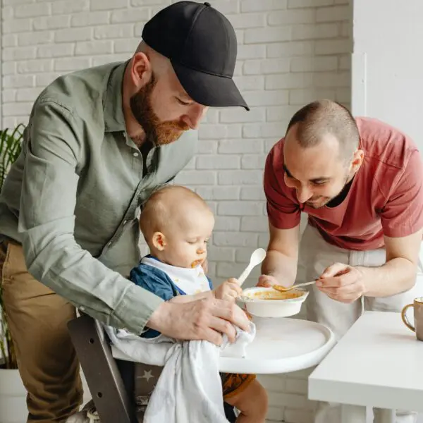 Papa's geven baby eten op kinderstoel